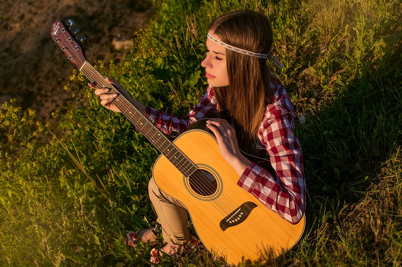 a woman sitting in the grass with a guitar, trending on pixabay, realism, young beautiful hippie girl, avatar image, perfect composition and lighting, wearing a headband