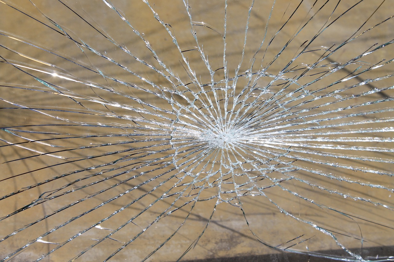 a broken glass window with a hole in it, a photo, outdoor photo, very accurate photo, high details photo, high res photo