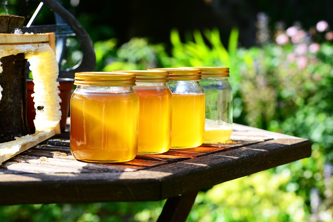 a wooden table topped with jars of honey, a picture, warm sunshine, high quality product image”, full of greenish liquid, growing