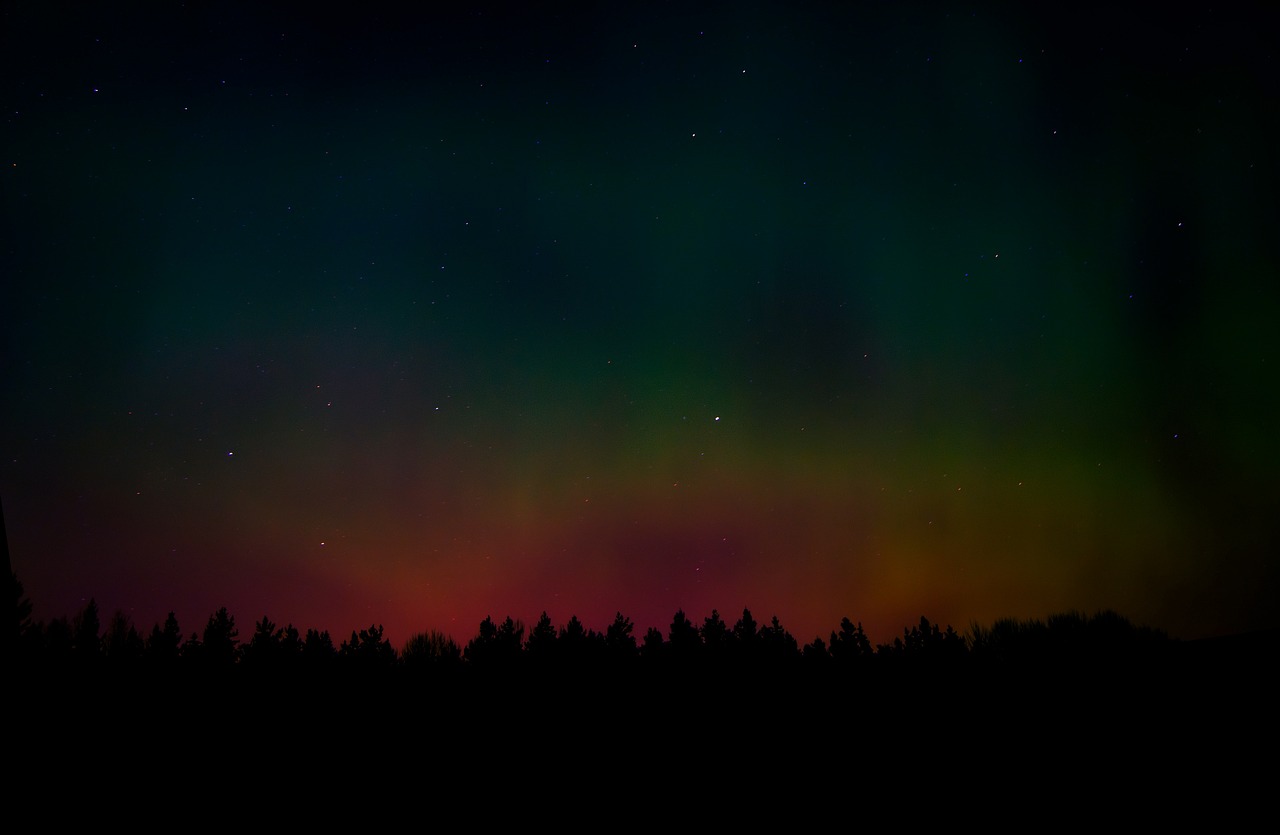 a sky filled with lots of green and red lights, a picture, by Anato Finnstark, shutterstock, quiet forest night scene, dark rainbow, warsaw, stary sky