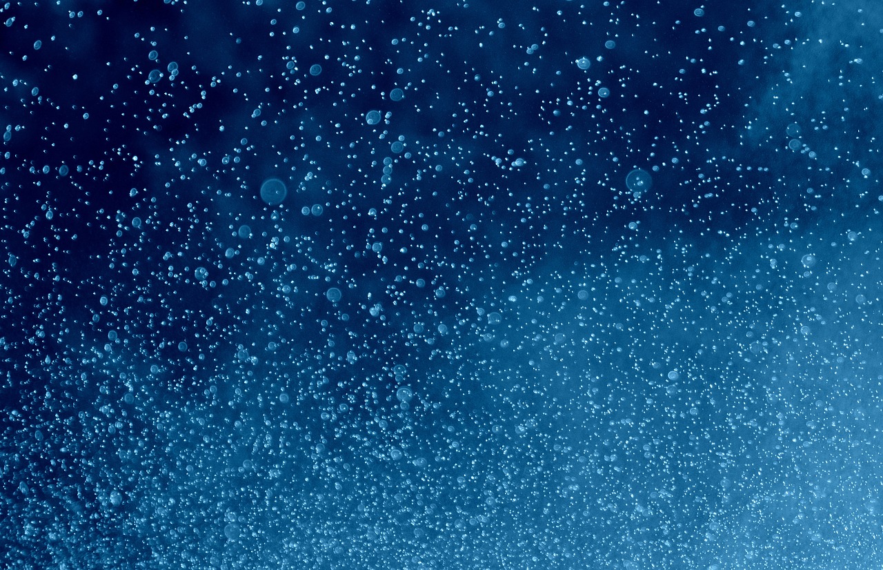 a close up of water bubbles on a blue background, a stipple, a dark underwater scene, low pressure system, drops are falling from above, lots of bubbles