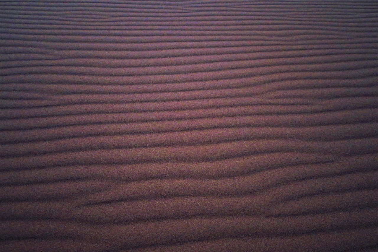 a close up of sand with a sky in the background, by Andrei Kolkoutine, op art, purple dim light, moist brown carpet, dunes, light dark