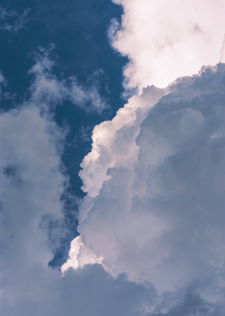 a jetliner flying through a cloudy blue sky, a picture, minimalism, giant cumulonimbus cloud, high angle vertical, low angle 8k hd nature photo, hoog detail