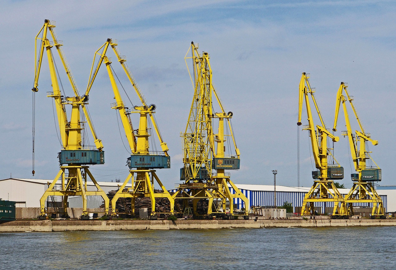a group of yellow cranes sitting on top of a body of water, shutterstock, soviet yard, hull, portal, dlsr photo