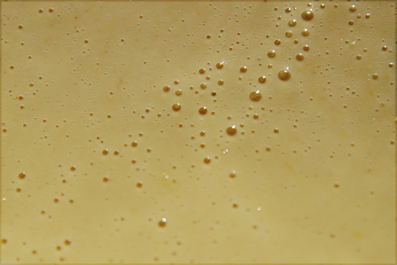 a close up of a glass of beer, a macro photograph, inspired by Jan Rustem, flickr, renaissance, wax skin, dots abstract, butter sculpture, bottom - view