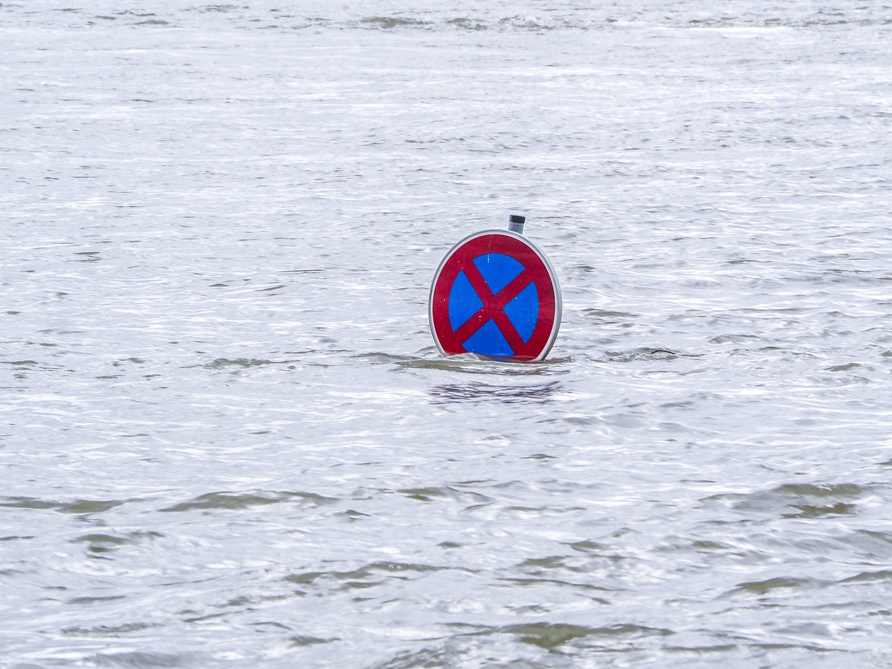 a sign in the middle of a body of water, a photo, by Jan Konůpek, shutterstock, floods, no helmet!!!!, circular, stock photo