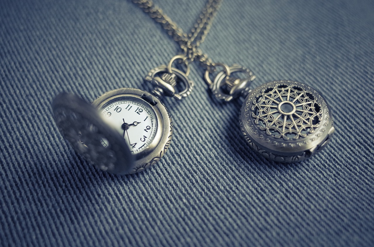 a close up of a pocket watch on a chain, a picture, trending on pixabay, minimalism, wearing several pendants, blue and grey, retro effect, intricate design