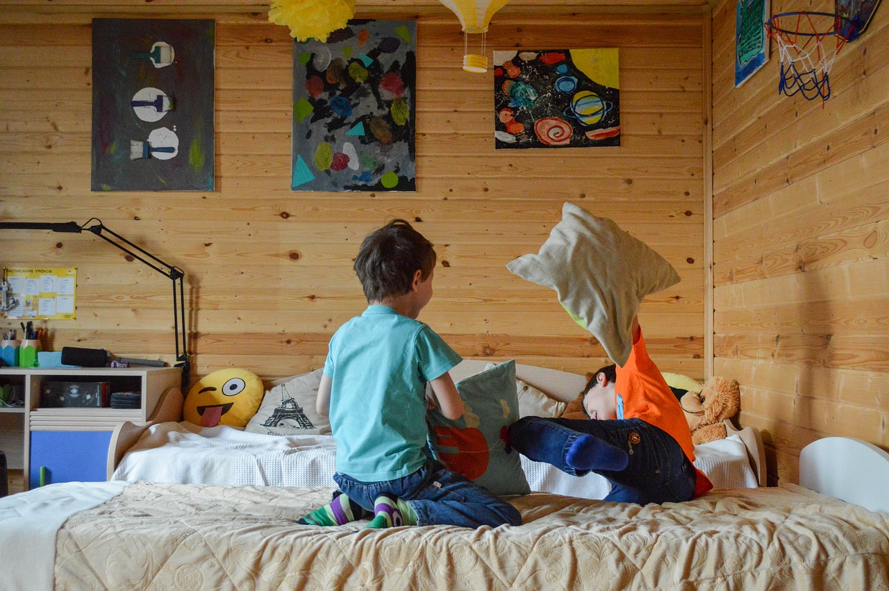 a little boy that is sitting on a bed, by Jaakko Mattila, pexels, visual art, in a cabin, in orange clothes) fight, img _ 9 7 5. raw, childs bedroom