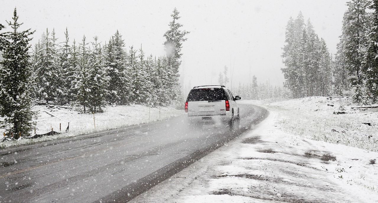 a white van driving down a snow covered road, driving a car, low pressure system, holiday season, featured