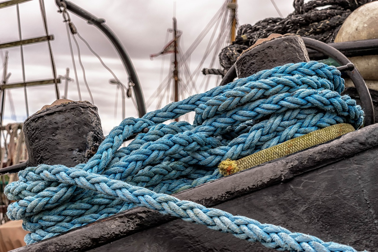 a close up of a rope on a boat, by Raymond Normand, process art, hdr photo, sailing ships, blue and black, colored accurately