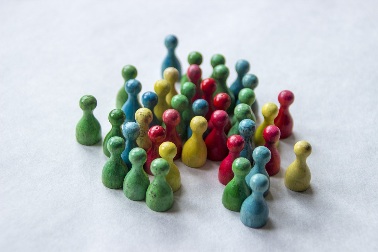 a group of colorful figurines sitting on top of a white surface, a tilt shift photo, cone heads, colored marble, teams, unframed
