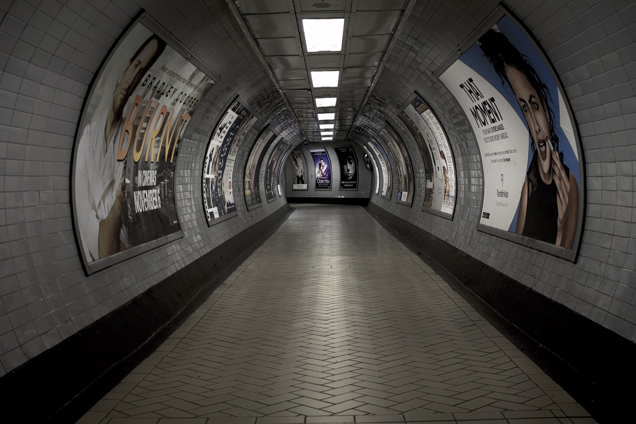 a subway tunnel with advertisements on the walls, inspired by Thomas Struth, flickr, hyperrealism, empty floor, 80s london city, long view, wide angel shot