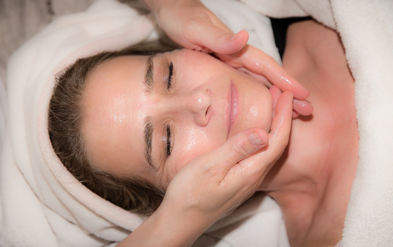 a woman getting a facial massage at a spa, a photo, headshot photo, hand on her chin, family friendly, épaule devant pose
