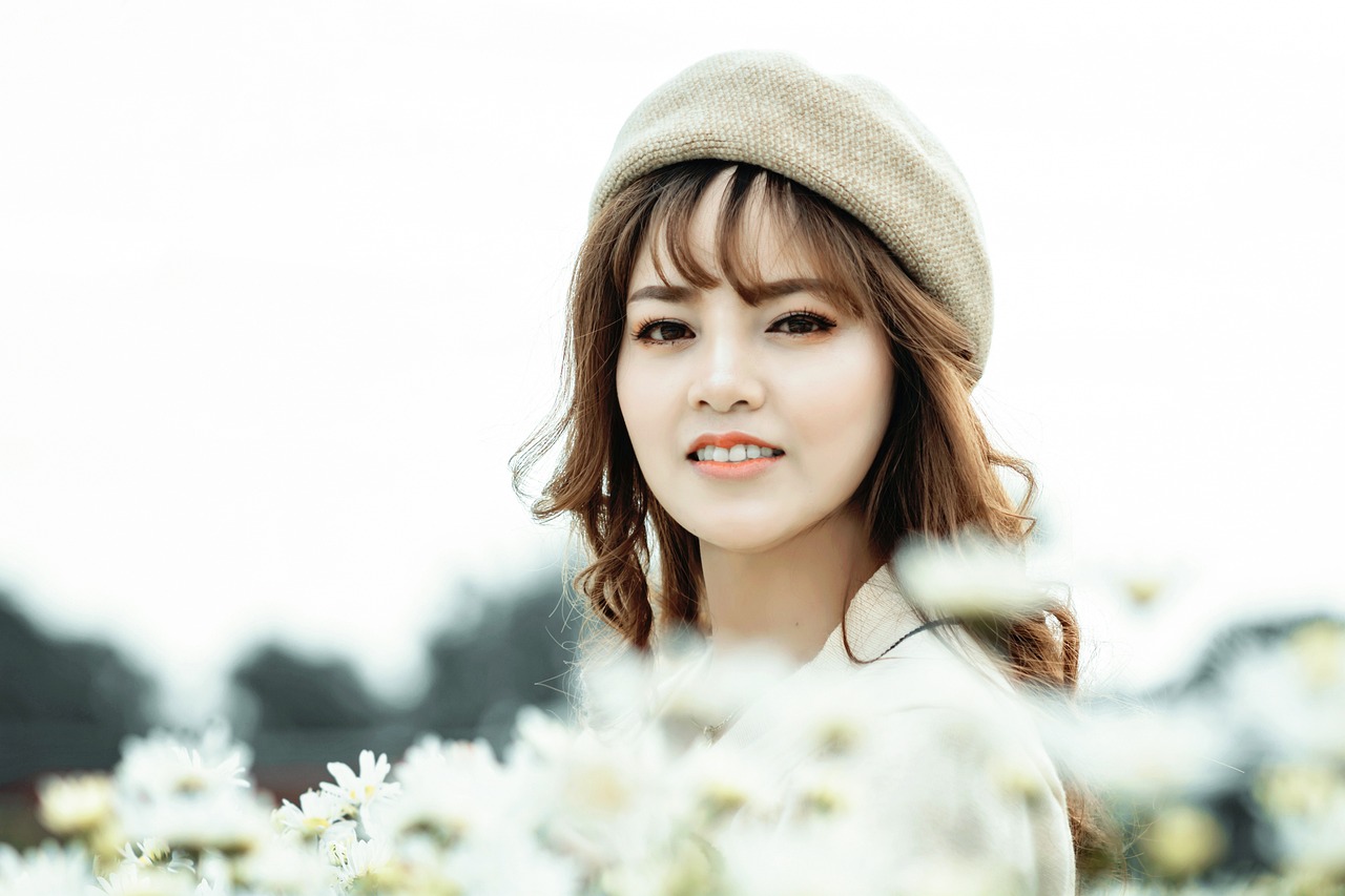 a woman standing in a field of white flowers, a picture, by Tan Ting-pho, shutterstock, realism, side portrait of cute girl, caracter with brown hat, close - up studio photo, handsome girl