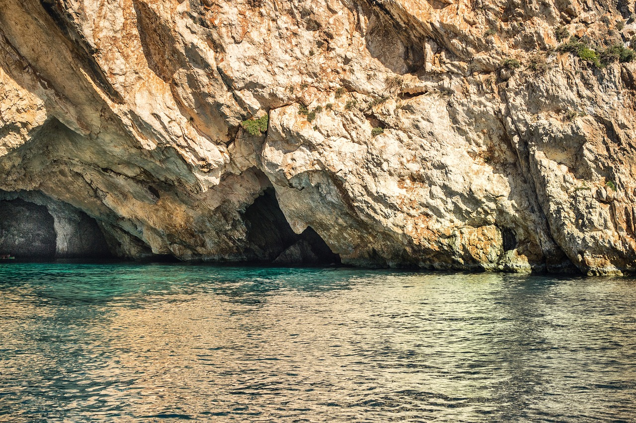 a cave in the middle of a body of water, a photo, by Fede Galizia, shutterstock, shady look, mediterranean features, slightly golden, texturized