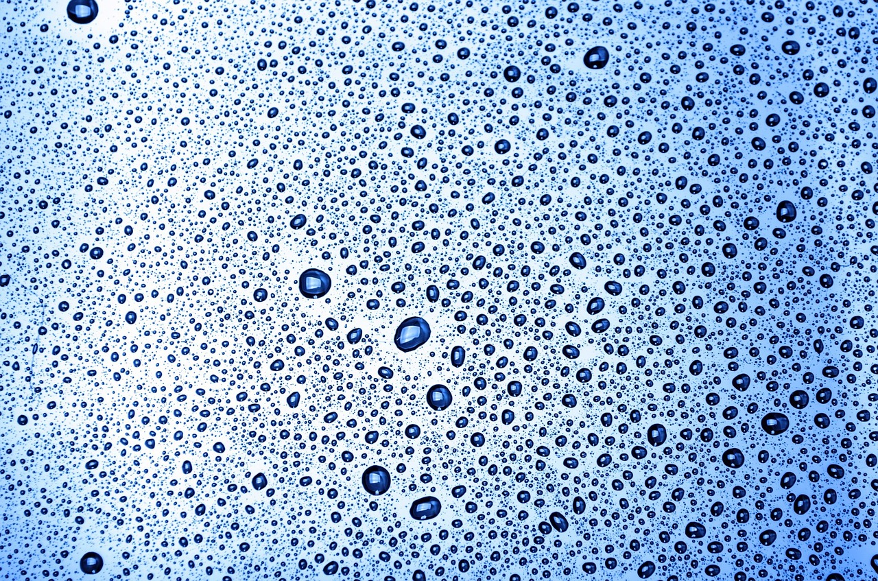 a close up of water droplets on a blue surface, a microscopic photo, by Jan Rustem, pointillism, bubble bath, high key detailed, vertical wallpaper, sun shining