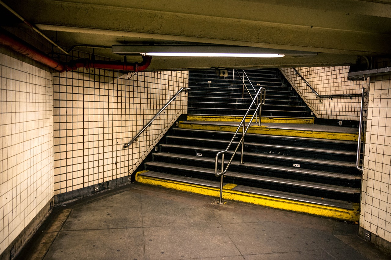 a set of stairs in a subway station, by Ben Stahl, flickr, madison square garden, sunken, low key, street level