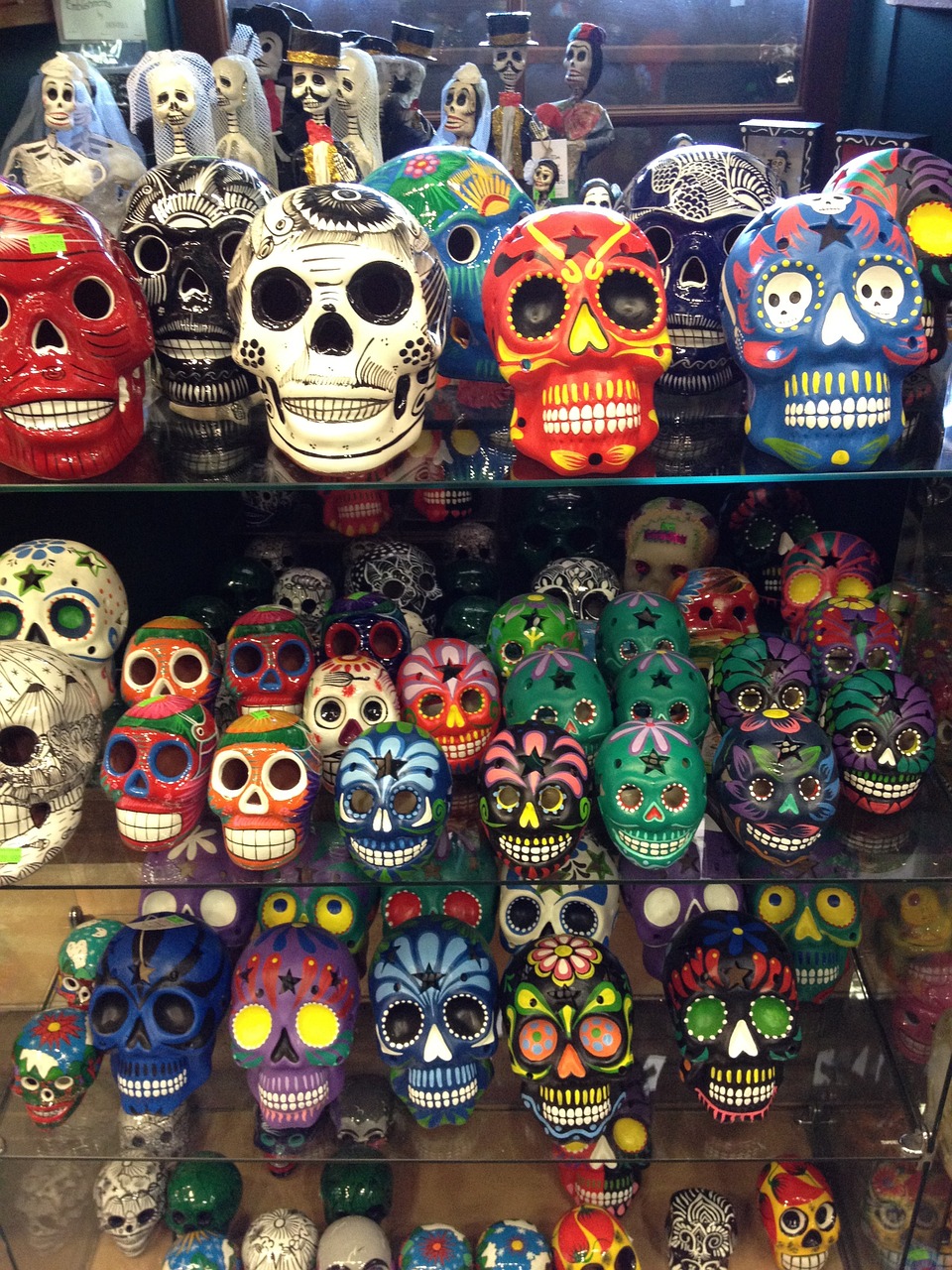 a display case filled with lots of colorful skulls, tumblr, toyism, tucson arizona, hispanic, horrifying :4, sky line