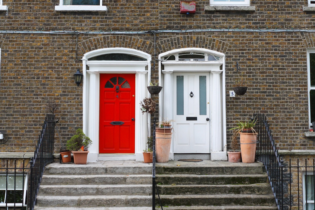 a red door sitting on the side of a brick building, by Edward Clark, shutterstock, white houses, 2 colours, 1811, portals