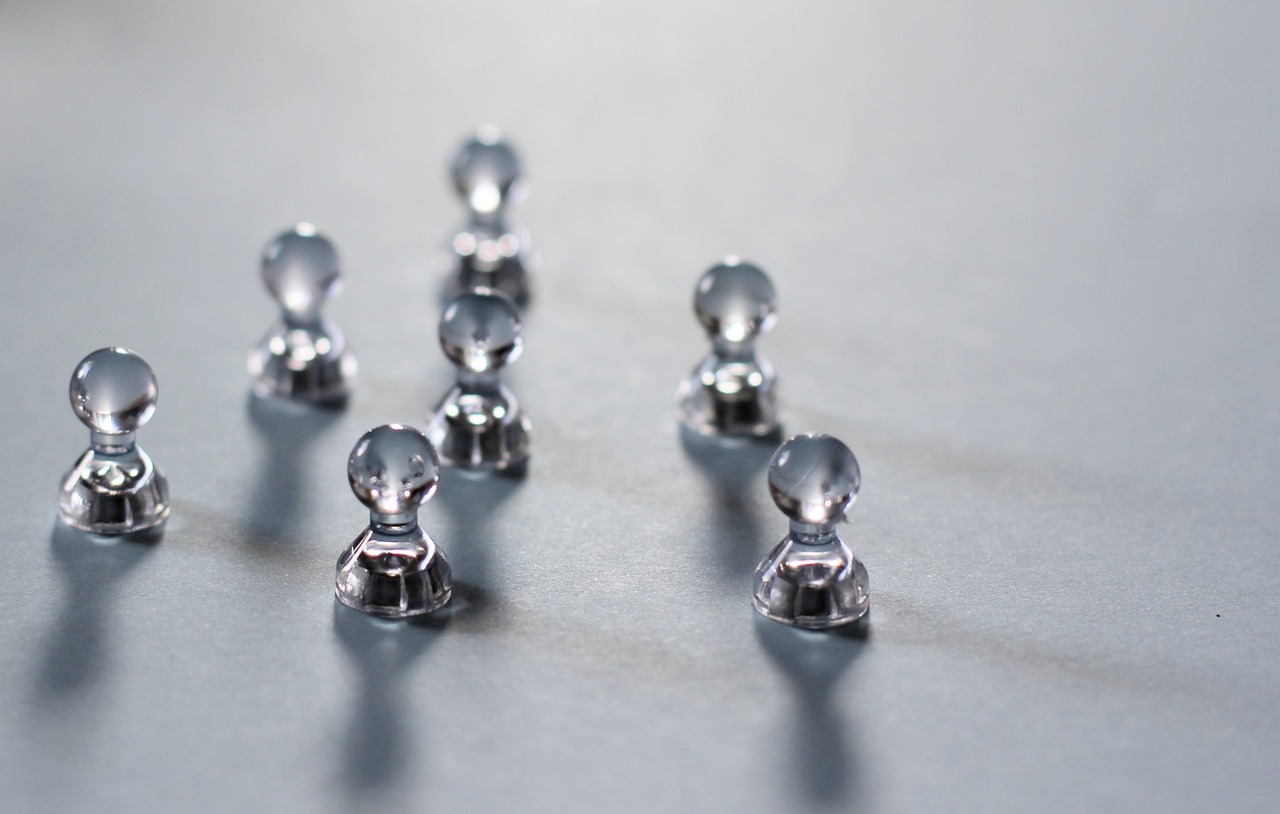 a group of silver figurines sitting on top of a table, a tilt shift photo, unsplash, the glass bead game, on a gray background, close-up product photo, rivets