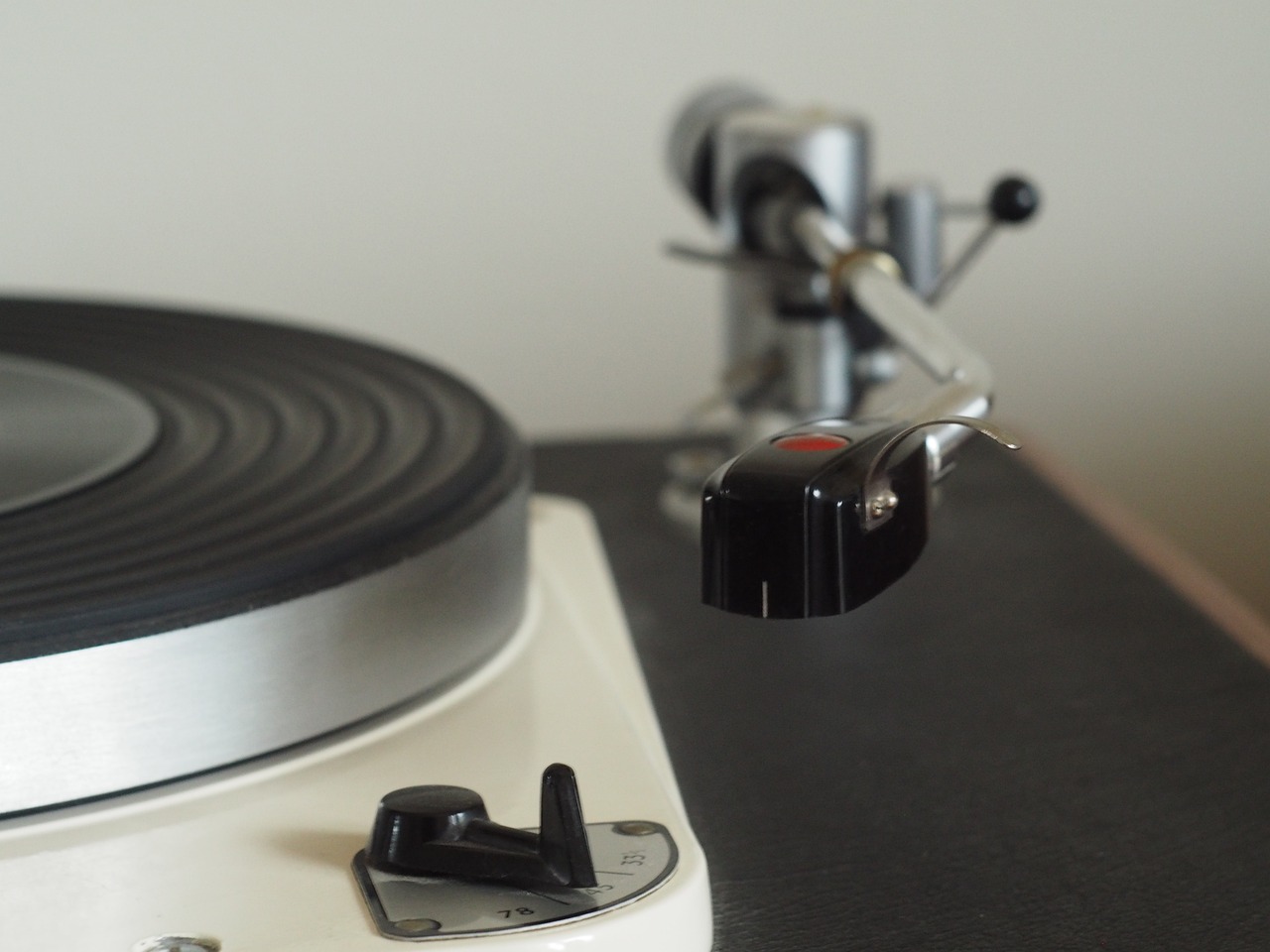 a close up of a turntable on a table, by Ottó Baditz, figuration libre, detailed trigger, 7 0 s photo, ivory and ebony, very accurate photo