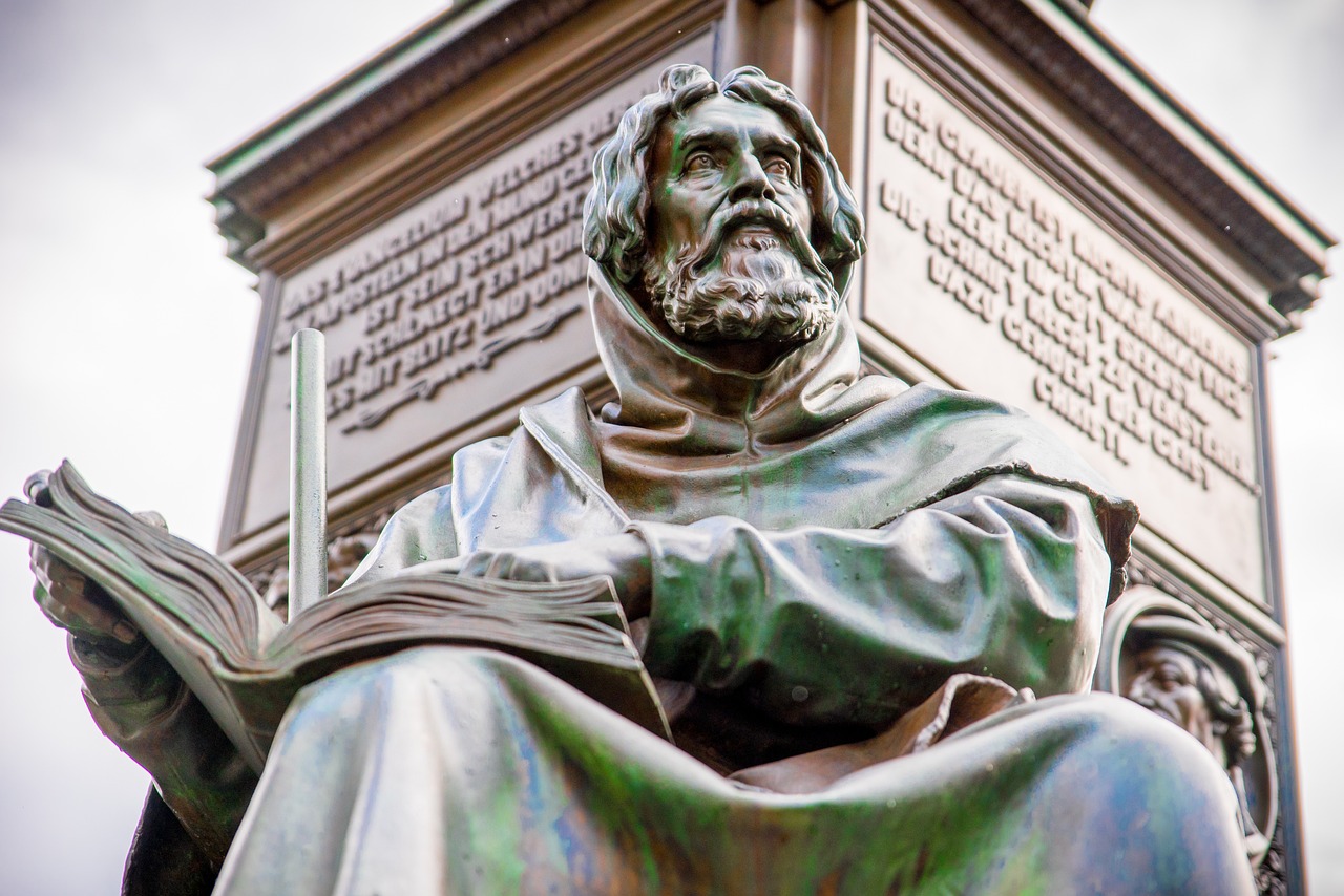 a statue of a man reading a book, a statue, inspired by Thomas Aquinas Daly, shutterstock, doctor doom, closeup photo, wideangle portrait, artem demura alphonse mucha