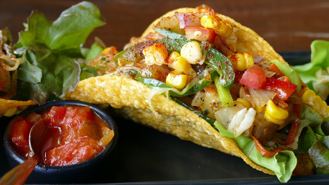 a couple of tacos sitting on top of a black plate, pixabay, renaissance, vibrantly colorful, with straw hat, condorito, oceanside