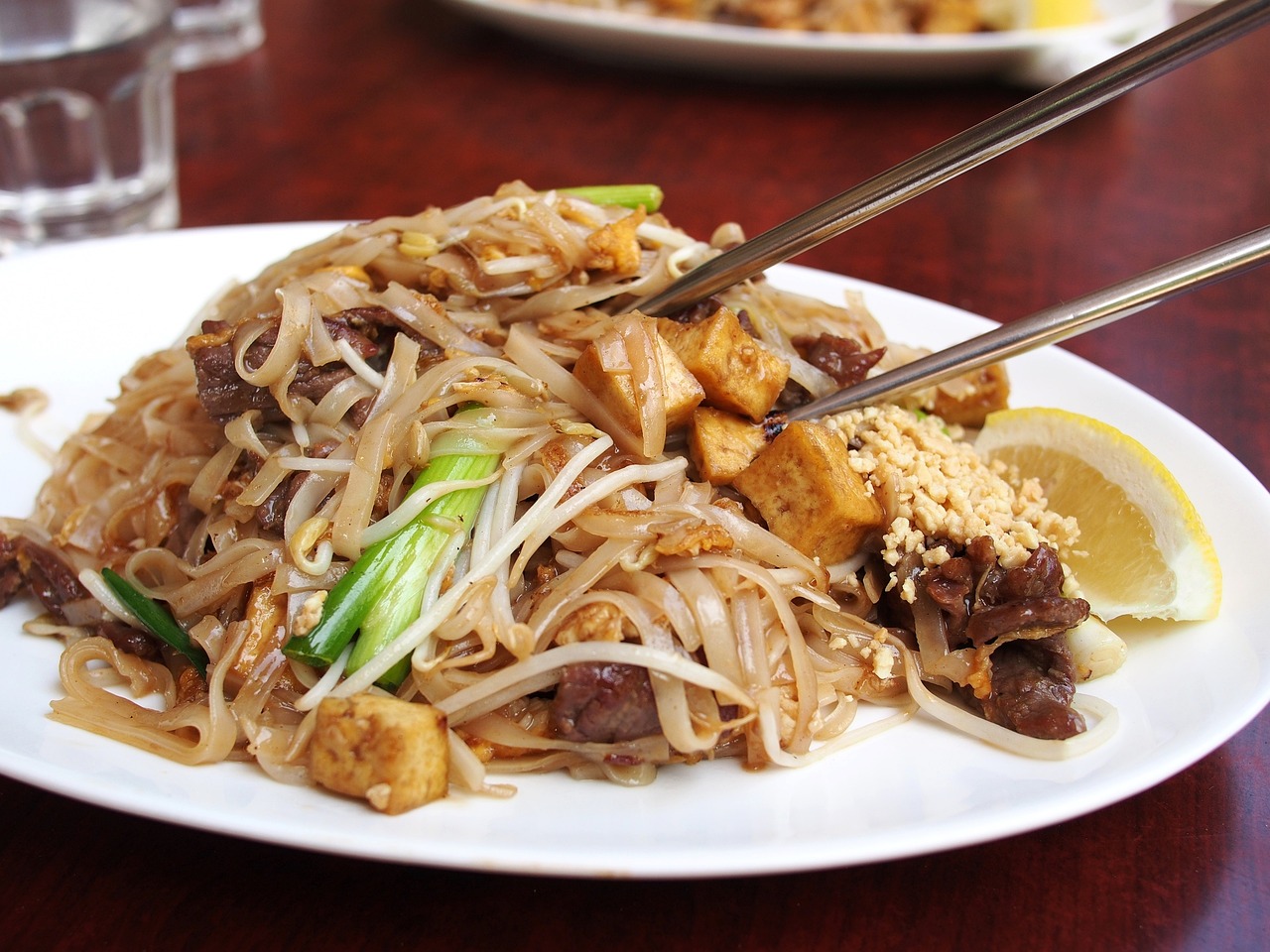 a close up of a plate of food with chopsticks, a picture, flickr, thai, square, noodles, stock photo