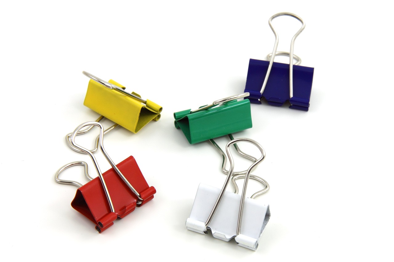 a group of paper clips sitting on top of each other, clamp style, painted with colour on white, dsrl photo, packshot