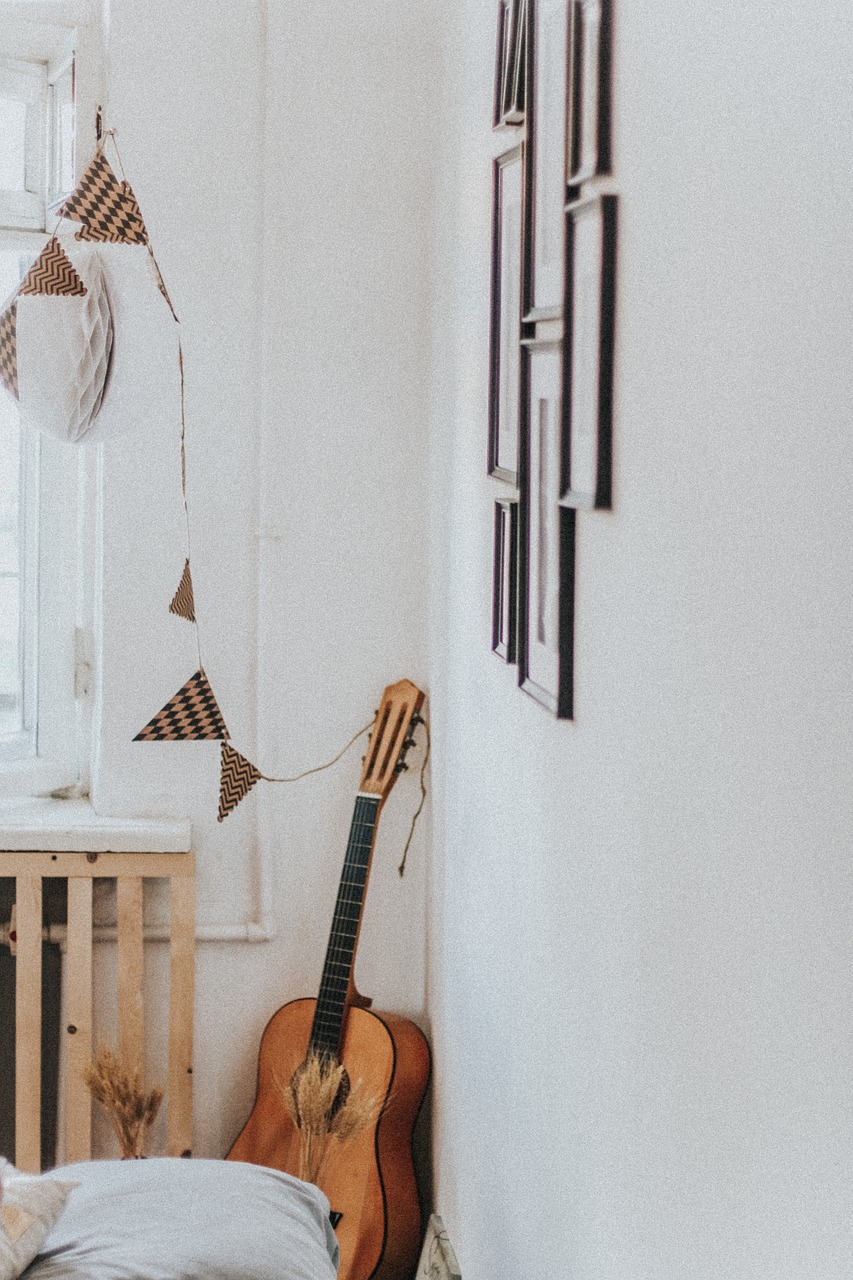 a guitar sitting on top of a bed next to a window, inspired by Béni Ferenczy, unsplash contest winner, childs bedroom, hanging scroll on wall, studio shot, nostalgia for a fairytale