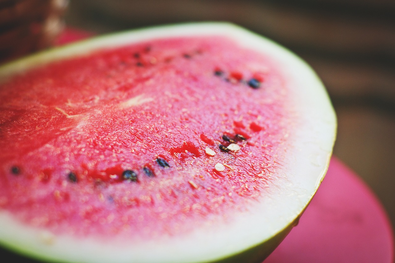 a slice of watermelon sitting on top of a pink plate, a macro photograph, pexels, hurufiyya, summer day, grainy photo, istockphoto, tyler west