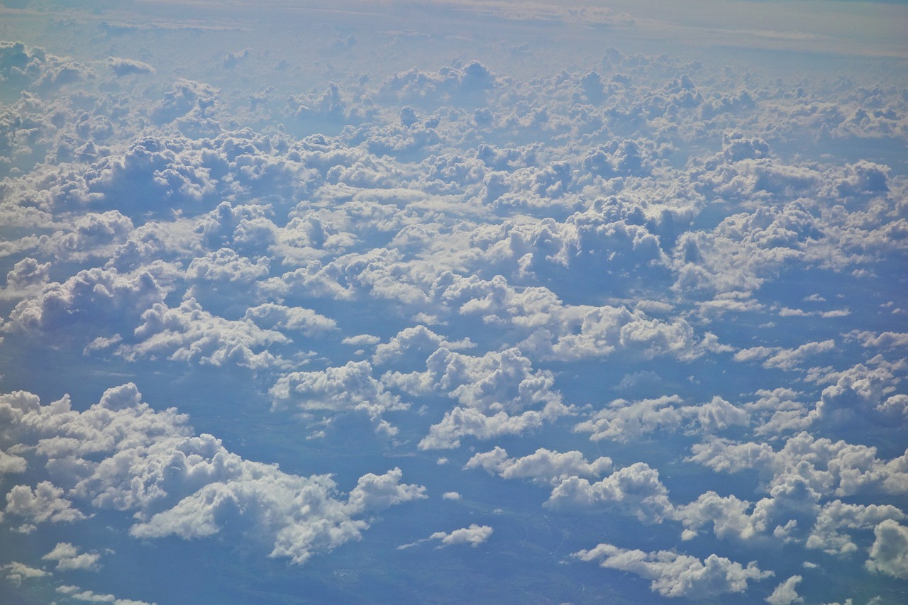 a blue sky filled with lots of white clouds, by Daniel Taylor, precisionism, bird\'s eye view, photo ( far _ shot ), heaven on earth, “puffy cloudscape