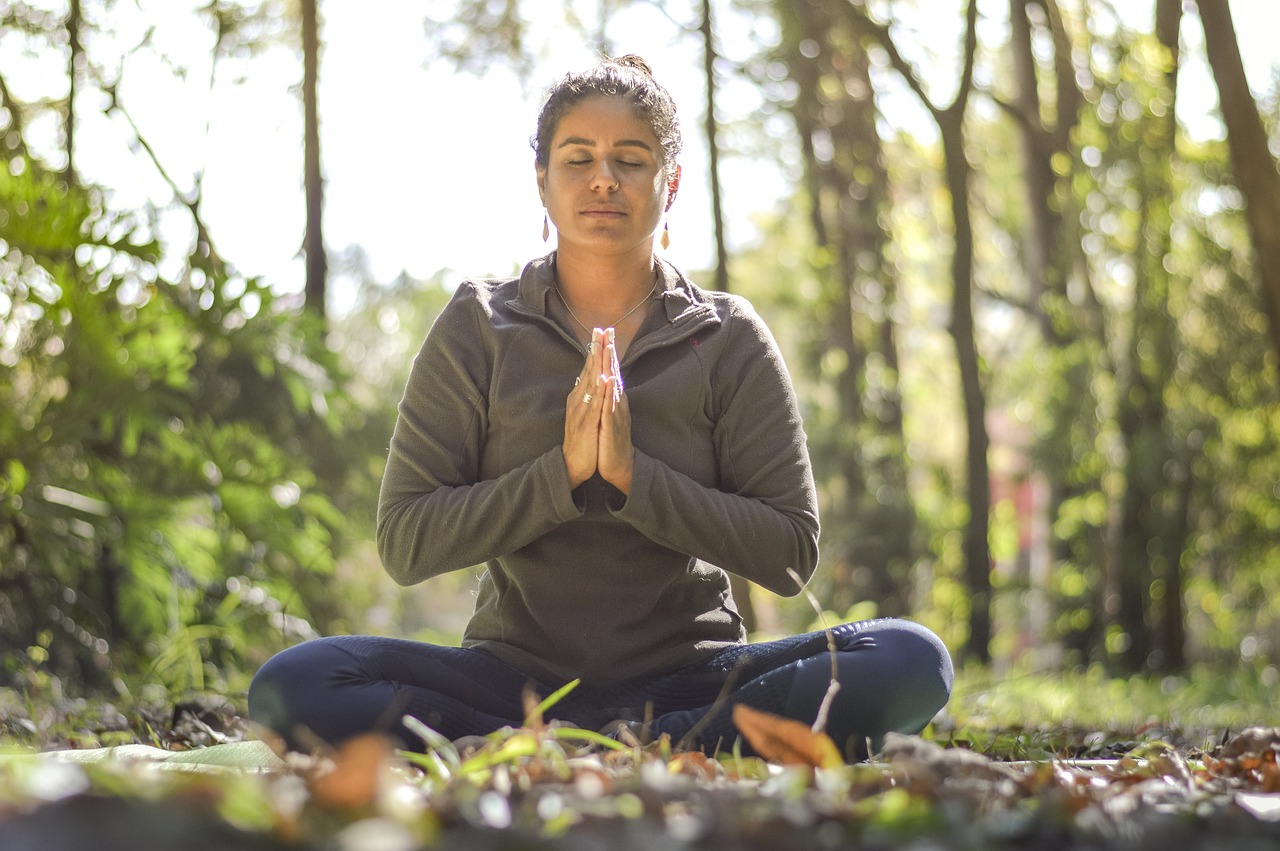 a woman sitting in the middle of a forest doing yoga, a portrait, praying posture, sunday afternoon, portrait image, front facing shot