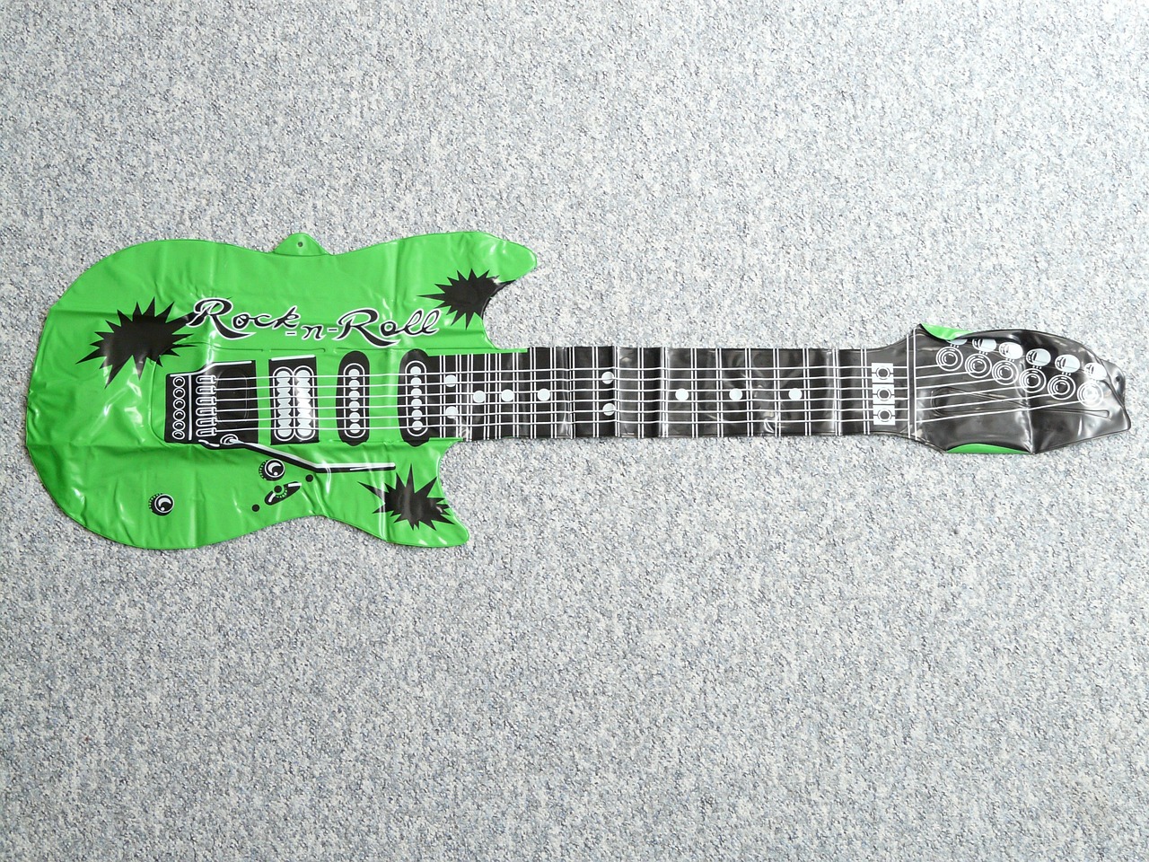 a green guitar sitting on top of a carpet, inspired by Rodney Joseph Burn, graffiti, metal readymade, on a gray background, high quality], ruanjia