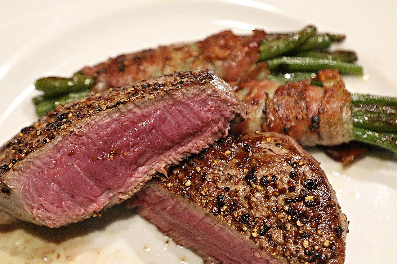 a white plate topped with meat and green beans, a picture, by Tom Carapic, meat texture, up close picture, hunting, arc