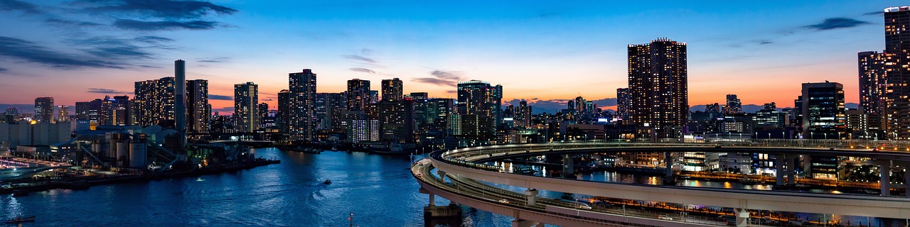 a river running through a city next to tall buildings, a stock photo, flickr, sōsaku hanga, highway and sunset!!, curved bridge, skyline view from a rooftop, ad image