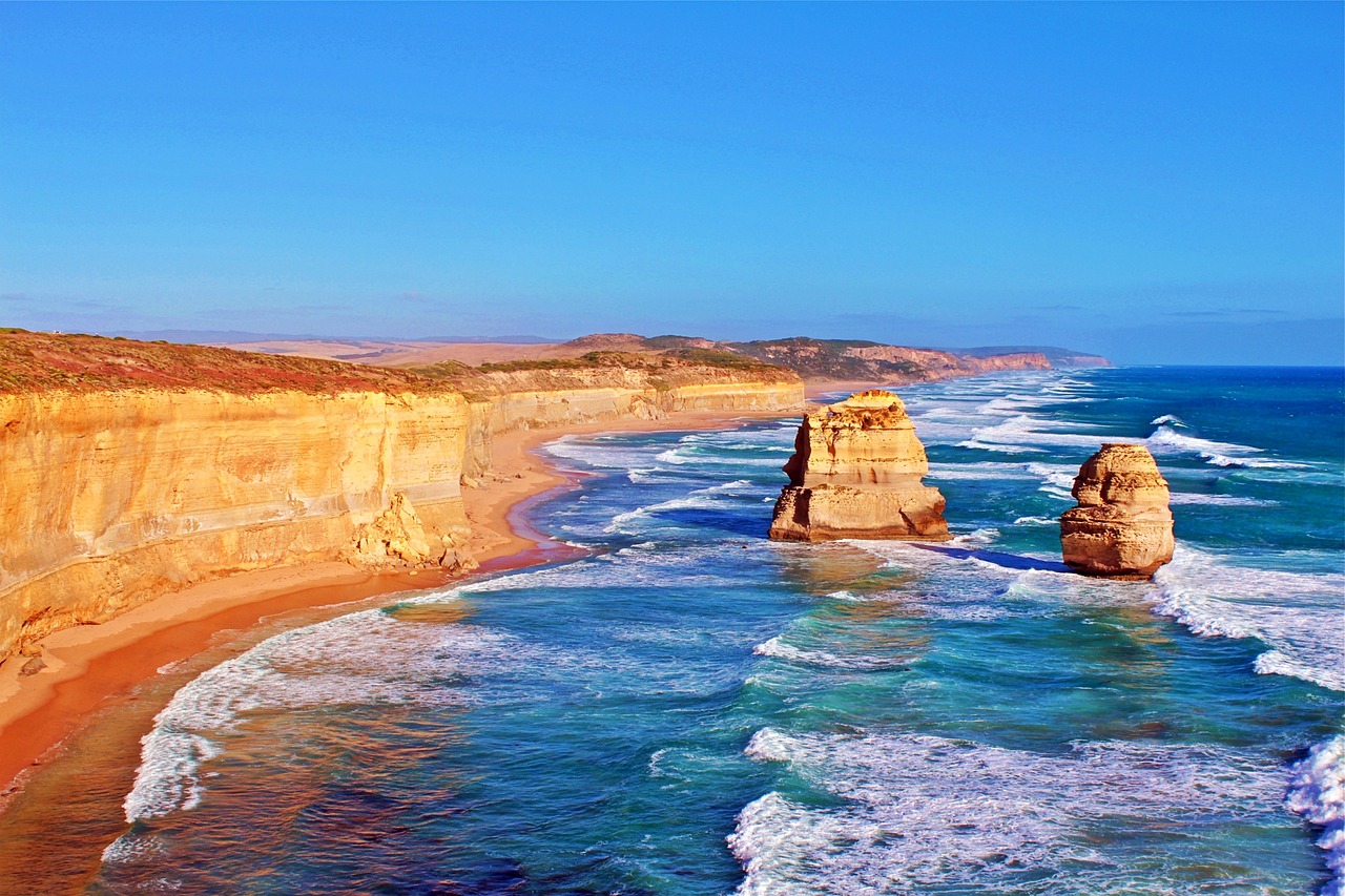 a couple of large rocks sticking out of the ocean, a tilt shift photo, by Robert Peak, shutterstock, on a hot australian day, panoramic widescreen view, victoria, caramel