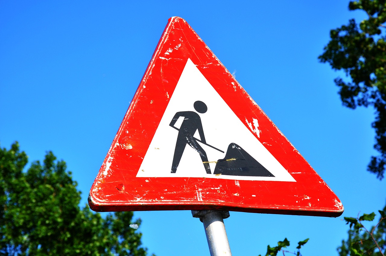 a close up of a street sign with trees in the background, by Mirko Rački, pixabay, happening, under construction, triangle, man, skidding