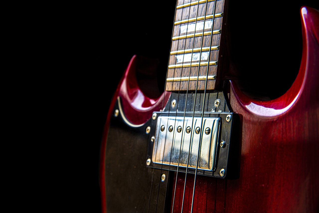 a close up of a red electric guitar, trending on pixabay, modernism, dark and grungy, from the 7 0 s, maroon metallic accents, with a black background