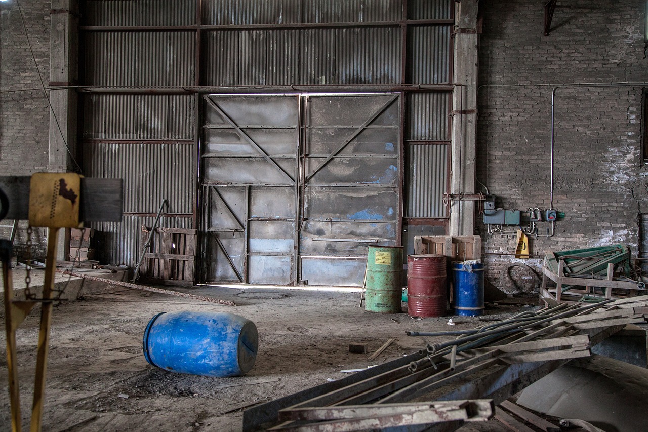 a bunch of barrels sitting inside of a building, a portrait, by Richard Carline, flickr, scrapyard, blue door, chemicals, img _ 9 7 5. raw