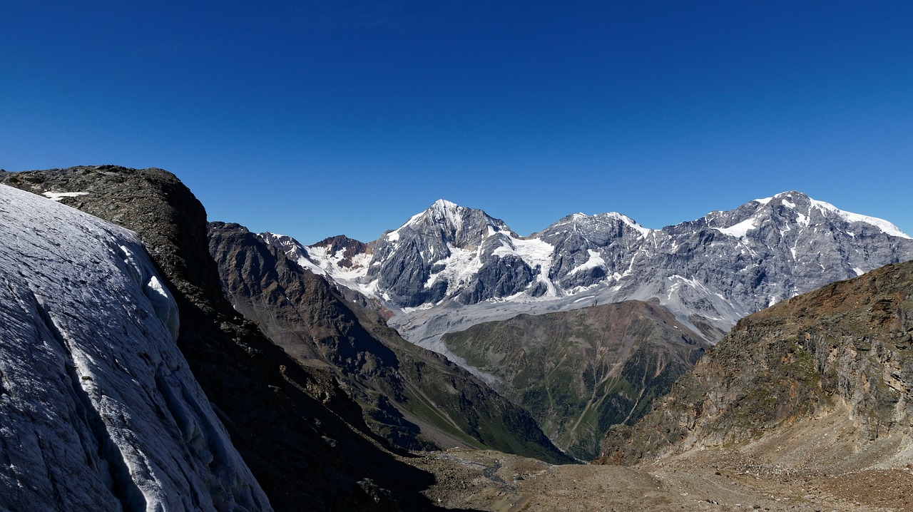 a man standing on top of a snow covered mountain, by Werner Andermatt, flickr, panorama distant view, glacier landscape, summer day, with a snowy mountain and ice