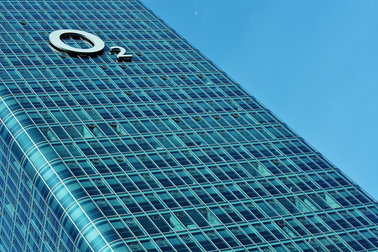 a very tall building with a clock on it's side, a stock photo, by Doug Ohlson, flickr, blue colour scheme, glass and metal : : peugot onyx, f2.2, executive industry banner