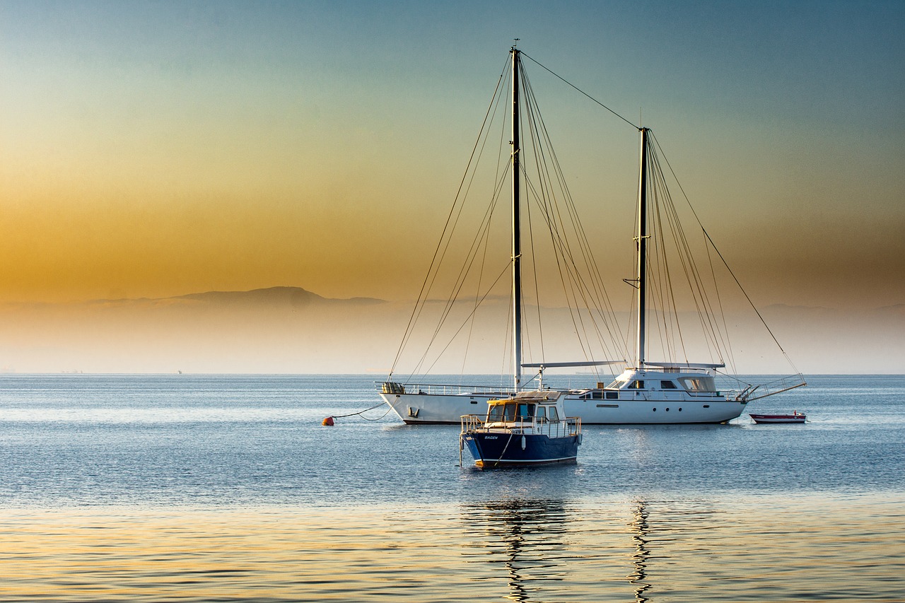 a couple of boats floating on top of a body of water, a picture, by Alexander Bogen, pixabay, three masts, morning glow, greek setting, today\'s featured photograph 4k