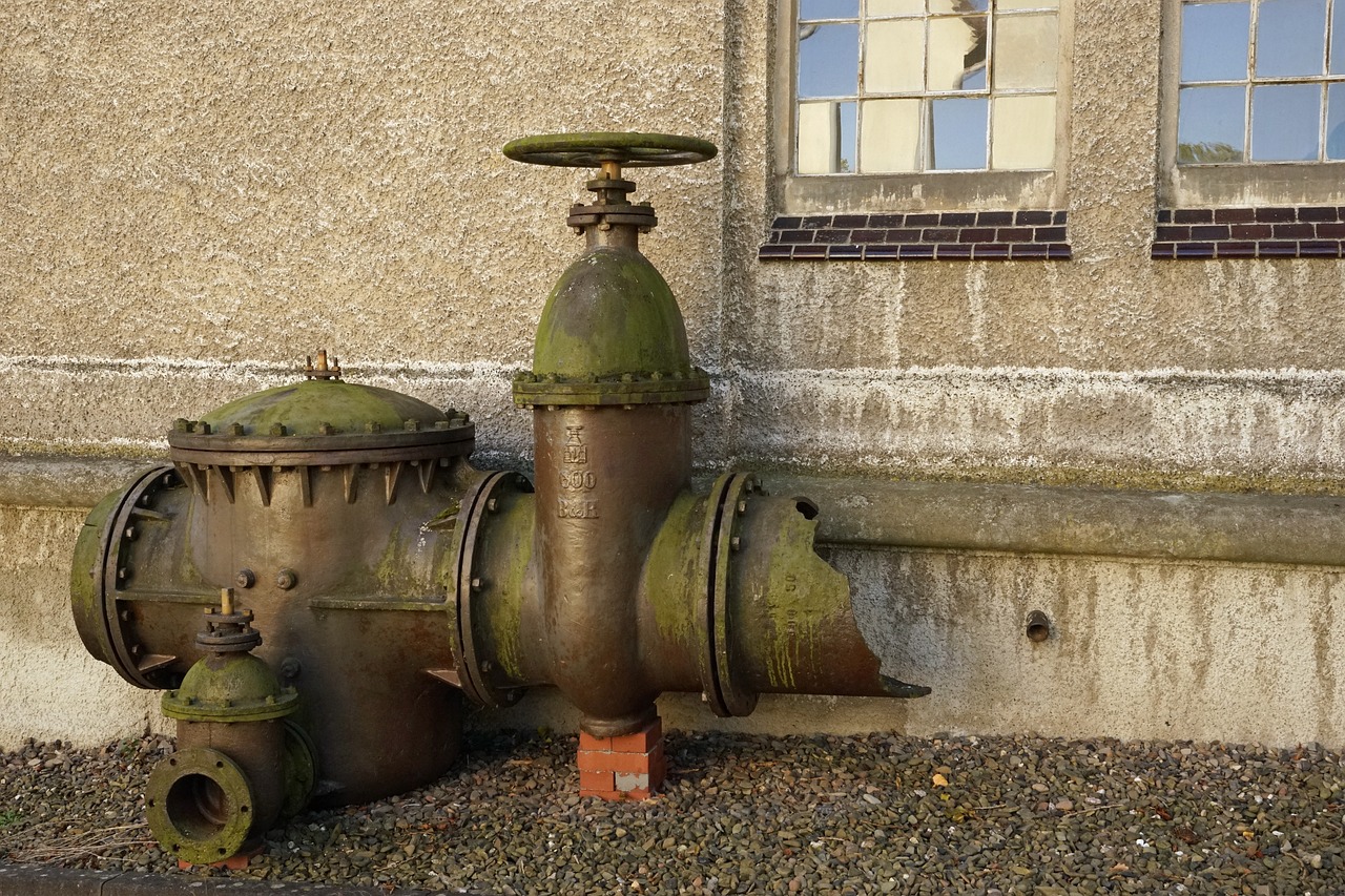 a close up of a fire hydrant near a building, a photo, assemblage, watertank, set in ww2 germany, large pipes, located in a castle