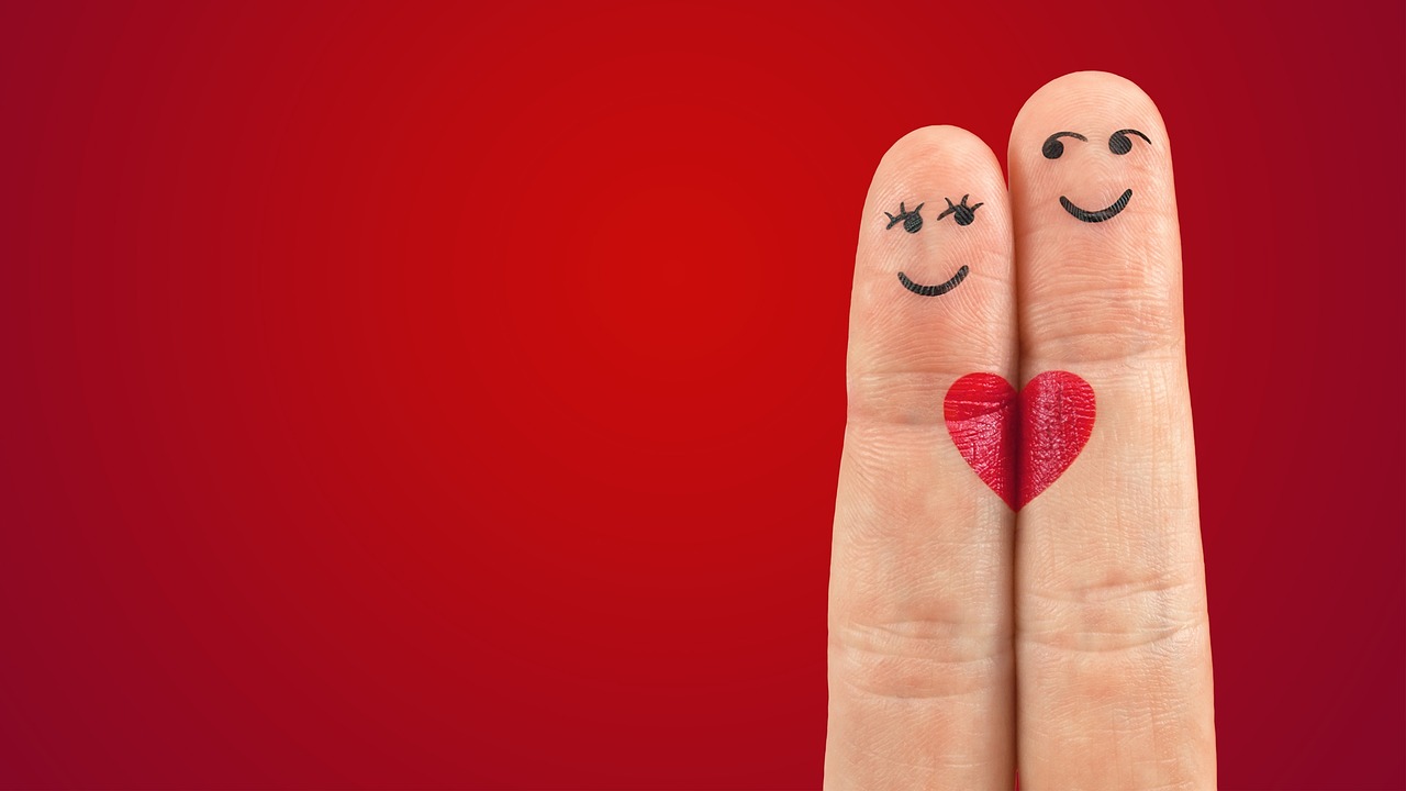 a couple of fingers with smiley faces painted on them, trending on pixabay, romanticism, in red background, heart - shaped face, slide show, with wart