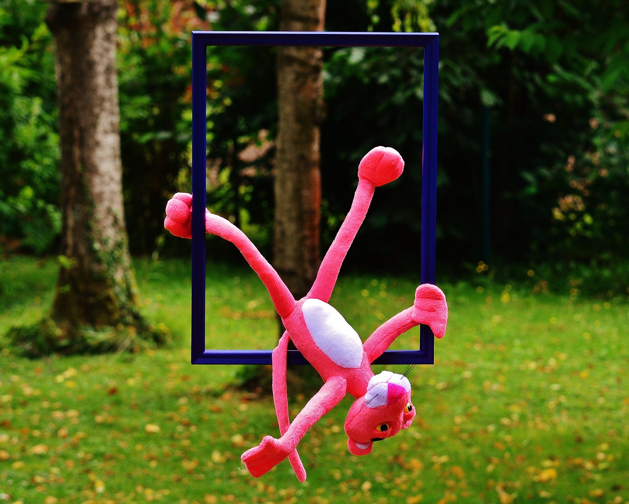 a pink stuffed animal hanging from a blue frame, a picture, inspired by Yves Klein, flickr, realism, outdoor photo, fully posable, flying anime esper, monkey