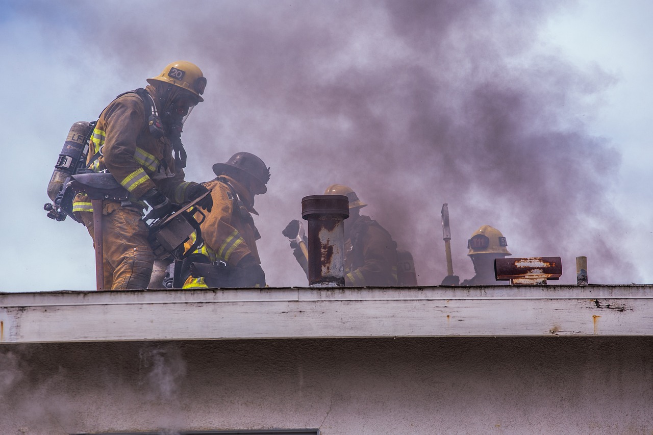 a group of firefighters standing on top of a building, a photo, by Scott M. Fischer, shutterstock, smoke under the ceiling, oceanside, closeup photo, focused photo