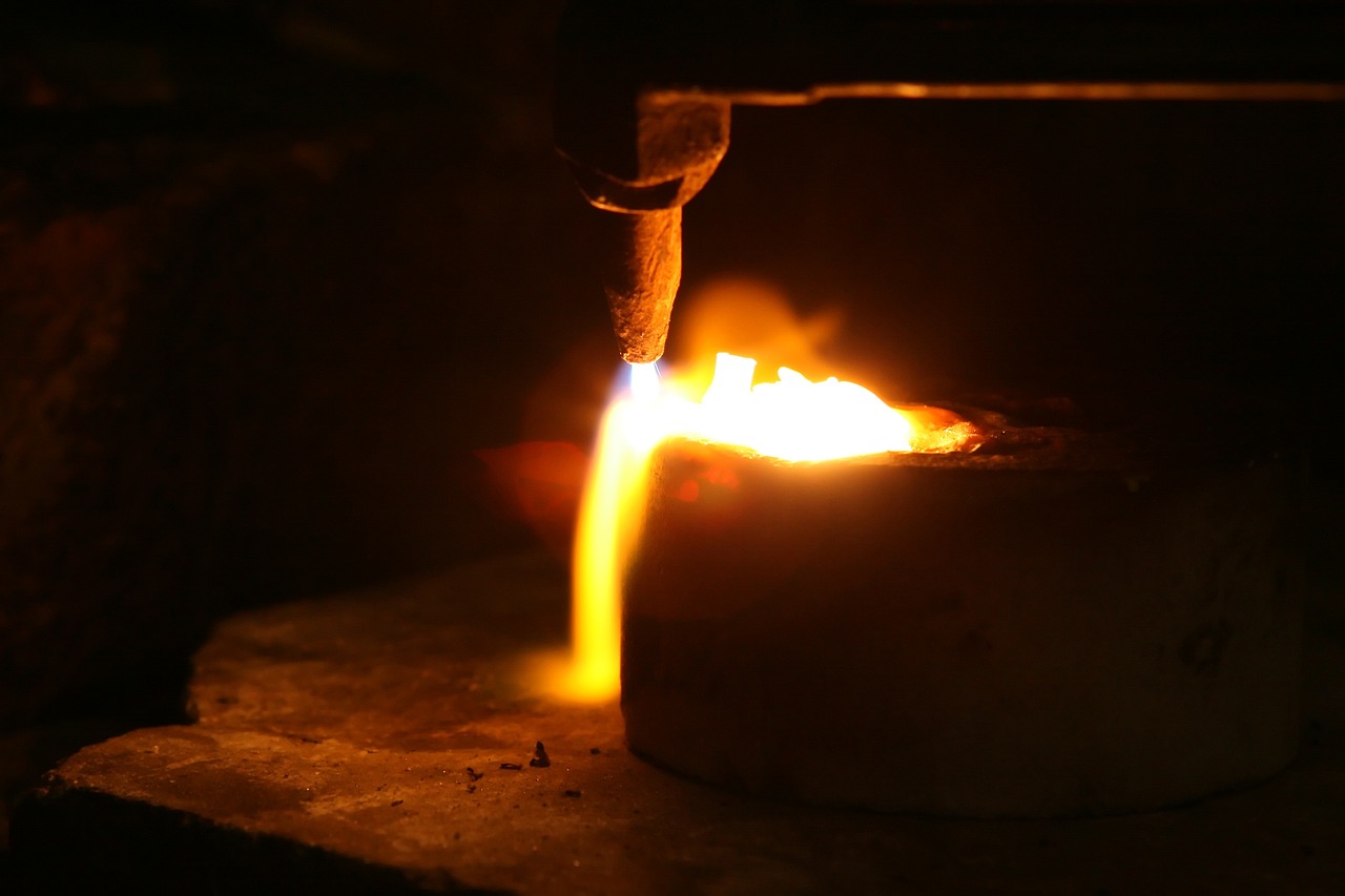 a close up of a metal object with a flame coming out of it, figuration libre, working in the forge, 8 0 mm photo, gold, high details photo