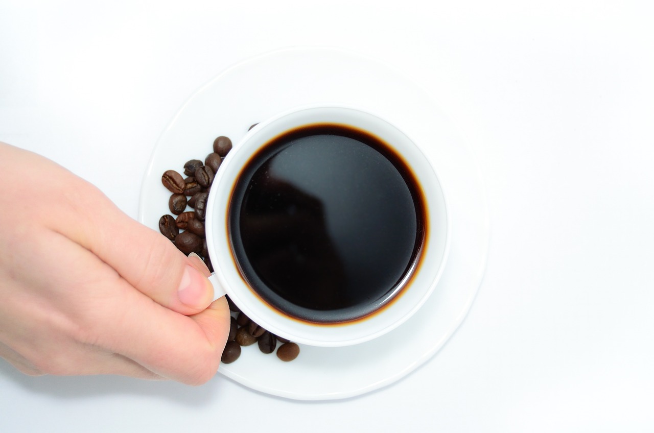 a close up of a person holding a cup of coffee, a stock photo, by Jan Kupecký, bauhaus, served on a plate, black color on white background, beans, closeup photo