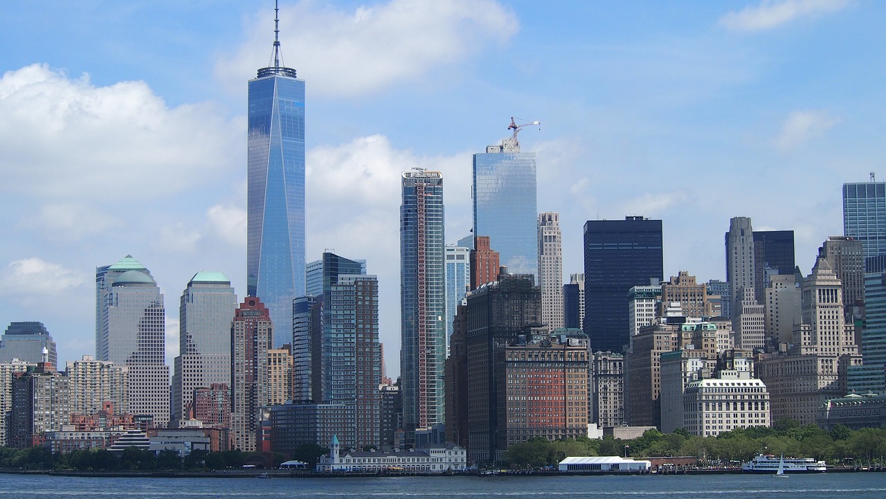 a large body of water with a city in the background, a picture, new york backdrop, the hard and strong buildings, banner, medium closeup